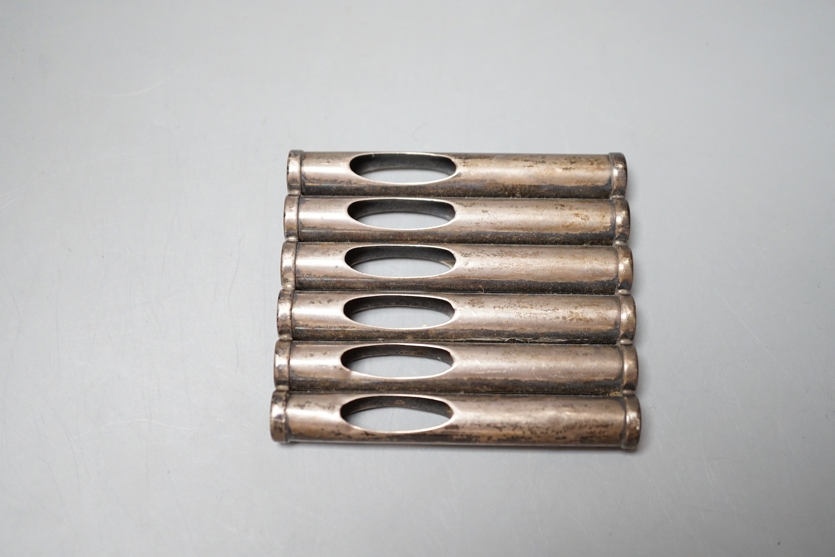 An Edwardian patent novelty cigarette holder, modelled as a magazine of bullets, William Maguires, Birmingham, 1904, 72mm.